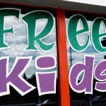 Painted sign in store window that says "Free Kids"